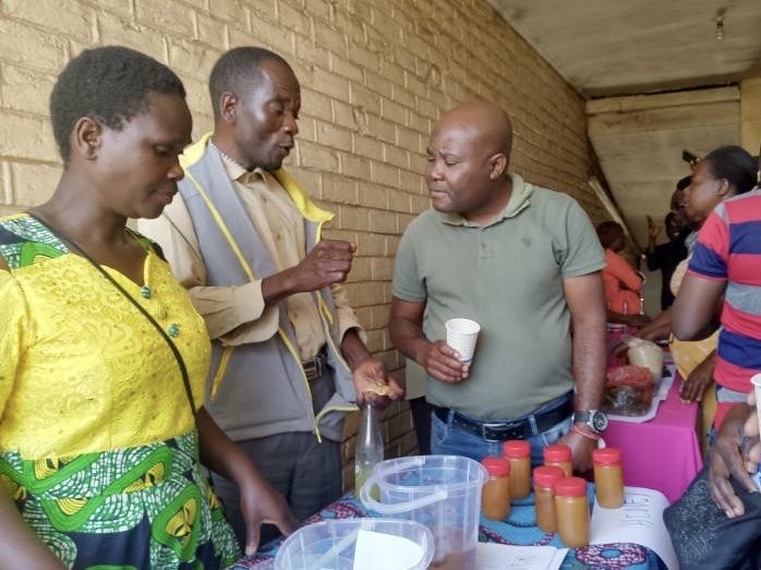 Vertreter*innen der Partnergemeinden präsentieren lokal hergestellte Produkte, wie Saft aus lokal angebauten Früchten. Foto: YSD Malawi.